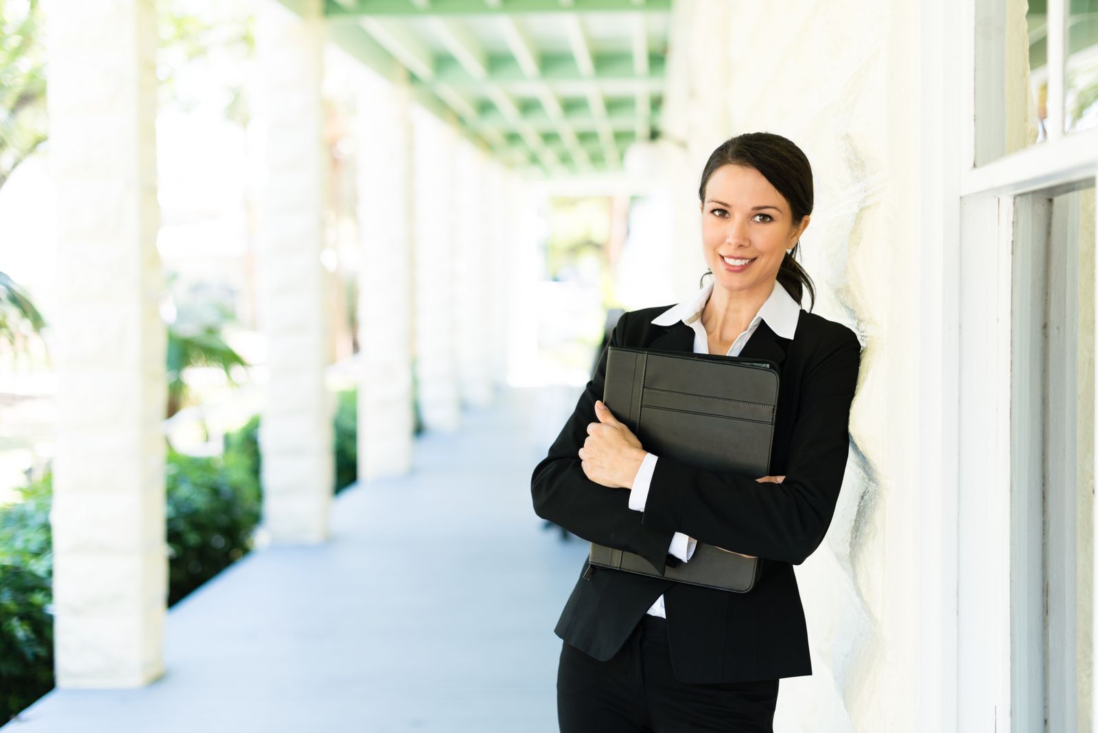 Attractive female woman real estate agent businesswoman on house veranda
